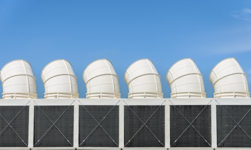 Industrial cooling towers or air cooled chillers against blue sky